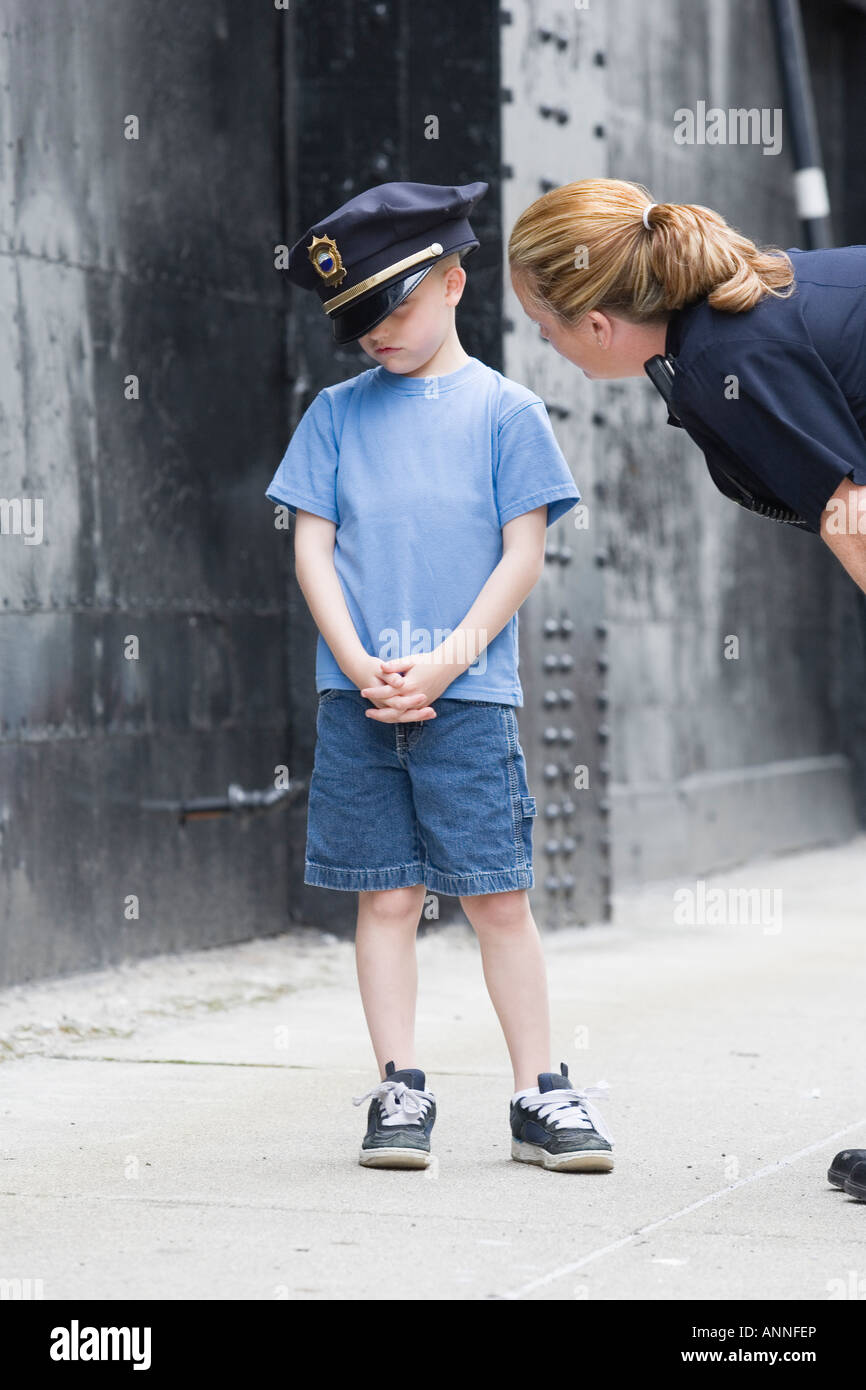 Woman police officer talking to a boy. Stock Photo