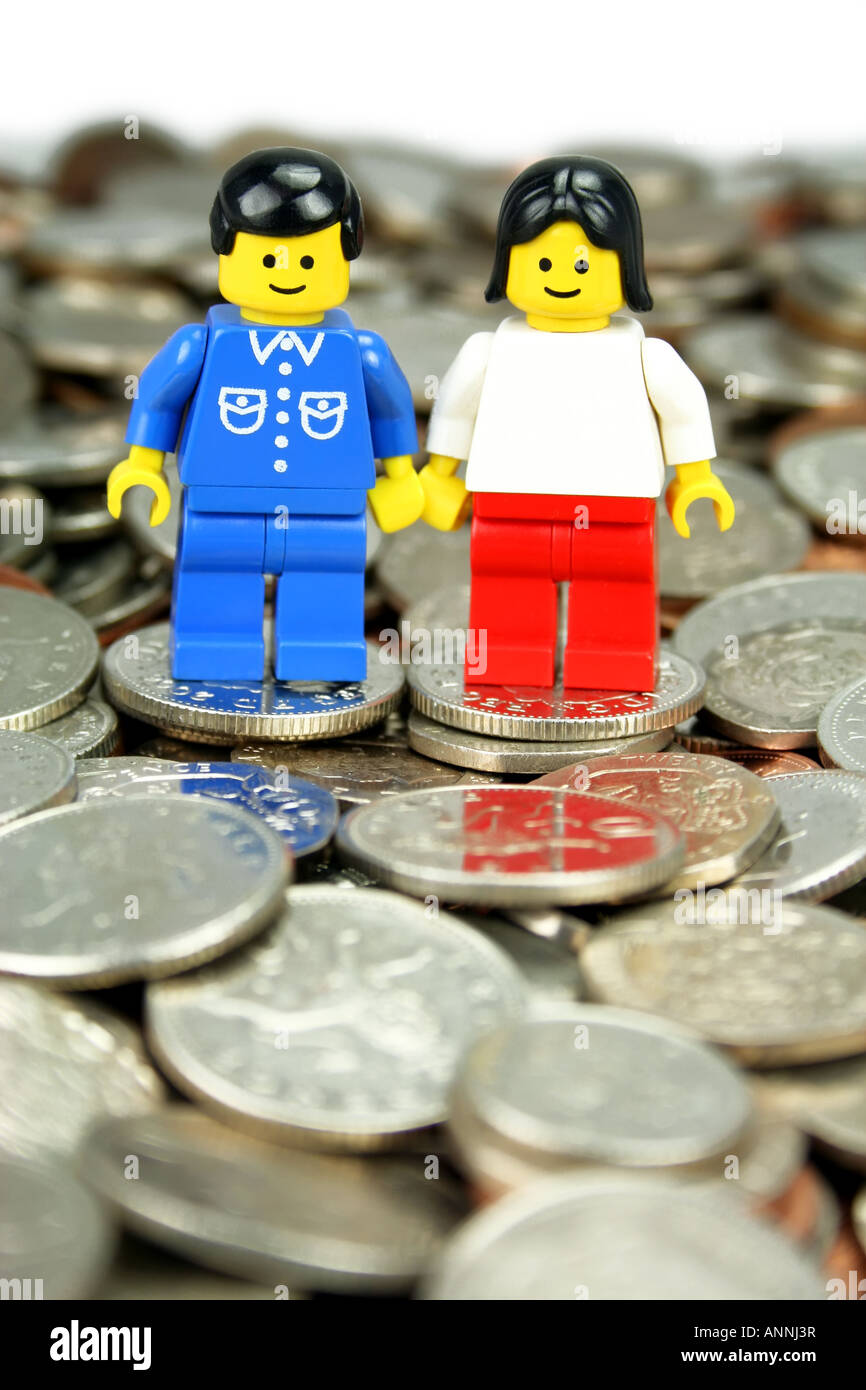 Lego man and woman standing on coins  - 'home finance' concept Stock Photo