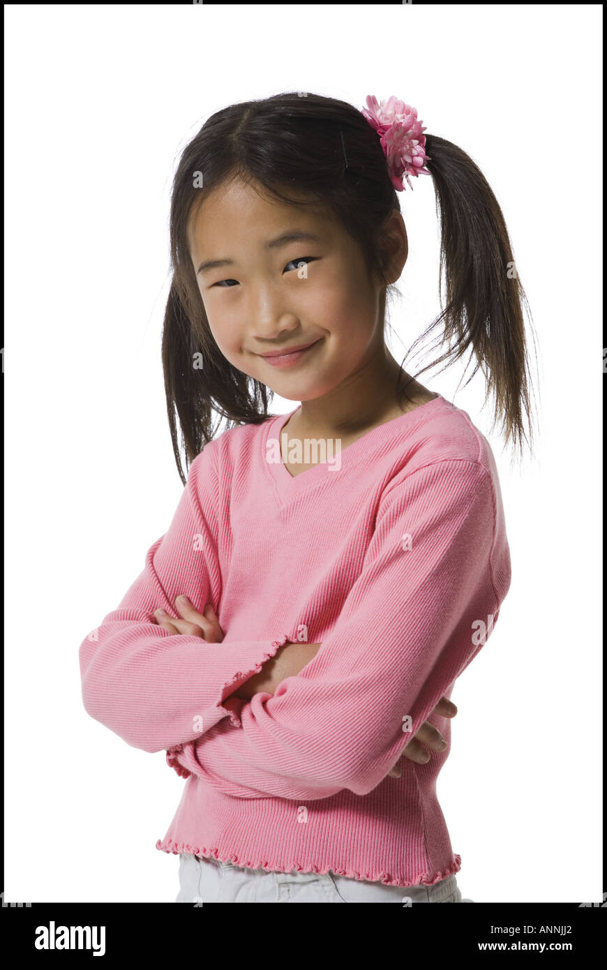 Portrait of a girl standing with her arms folded and smiling Stock Photo