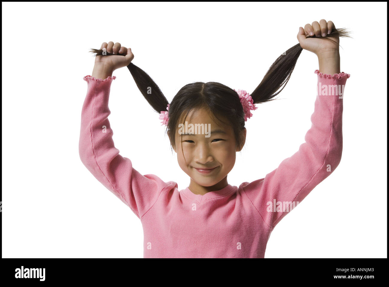Portrait of a girl holding up her pigtails and smiling Stock Photo