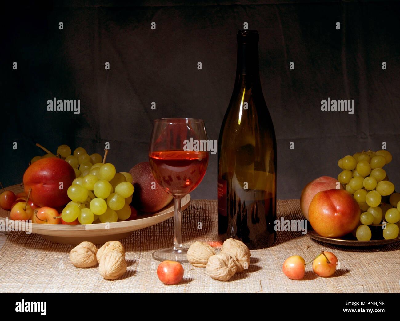 Classic still life featuring a colorful bowl of fruit and a wine bottle ...