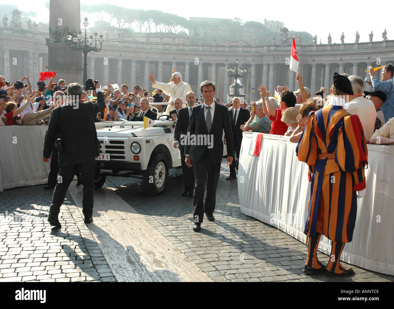 Pope Benedict XVI greets pilgrims attending a papal audience in Rome s St Peter Square the basilica's huge piazza Stock Photo