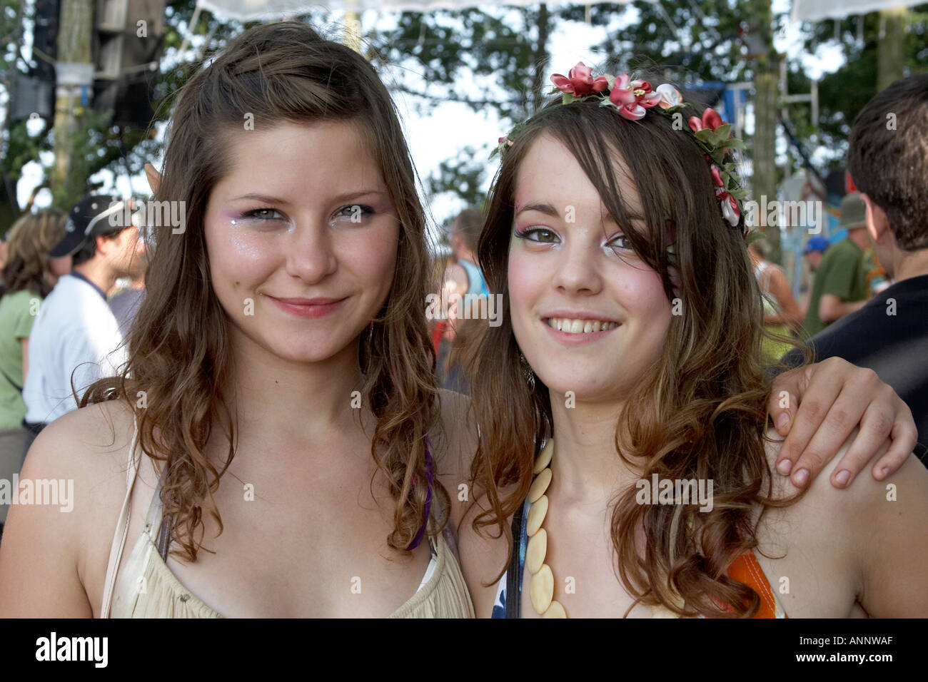 Two smiling girls in the glade at Glastonbury Festival of Contemporary Performing Arts Somerset England UK 2005  Stock Photo