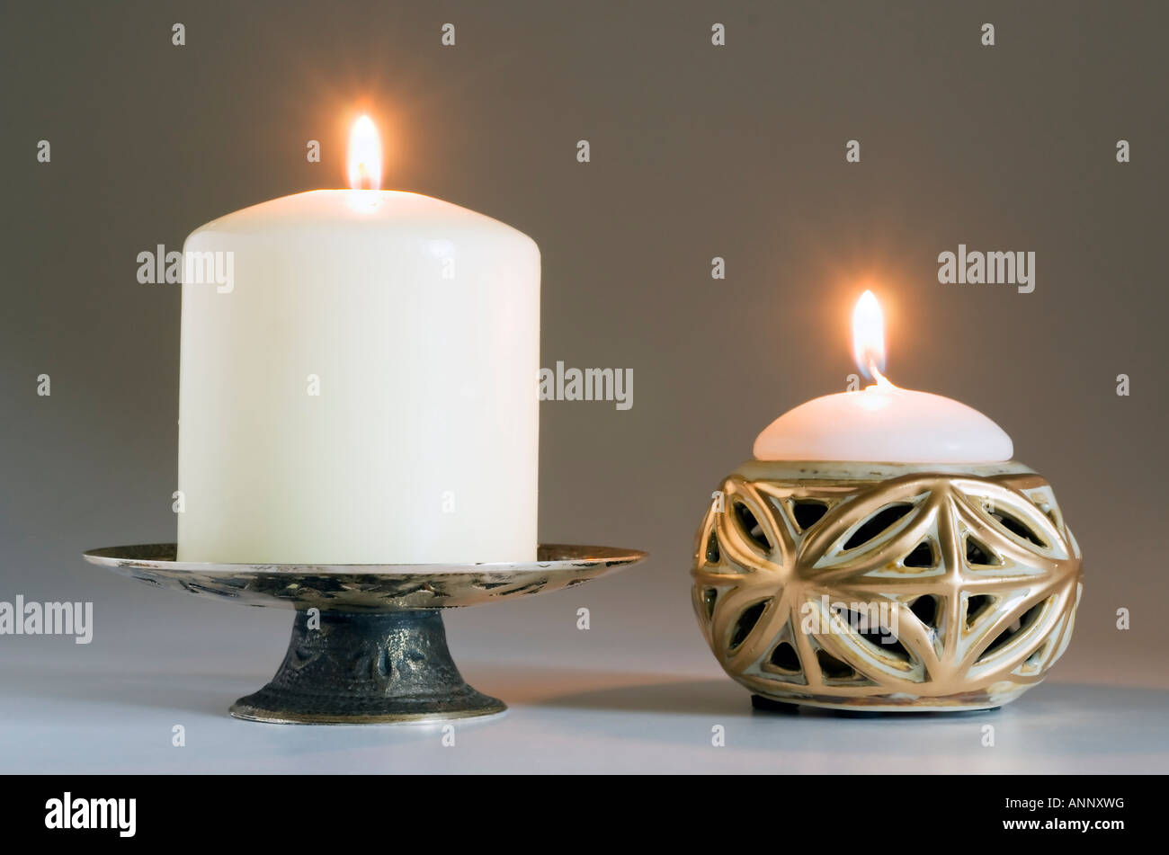 Two lit candles with holders Stock Photo Alamy