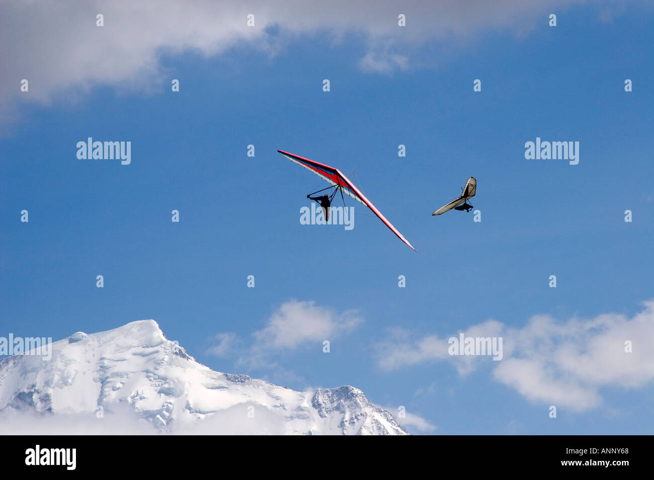 Hang gliding pilots flying hang gliders in snowy mountains of French