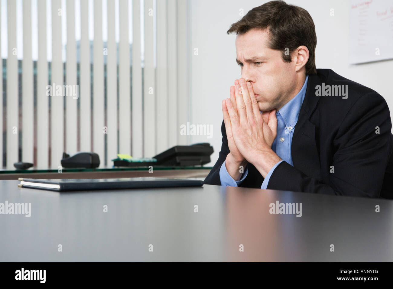 View of a contemplative businessman sitting in an office. Stock Photo