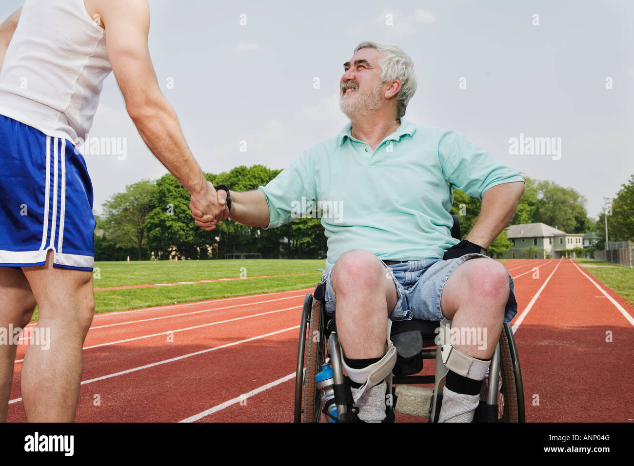 Handicapped senior man shaking hand with a man. Stock Photo
