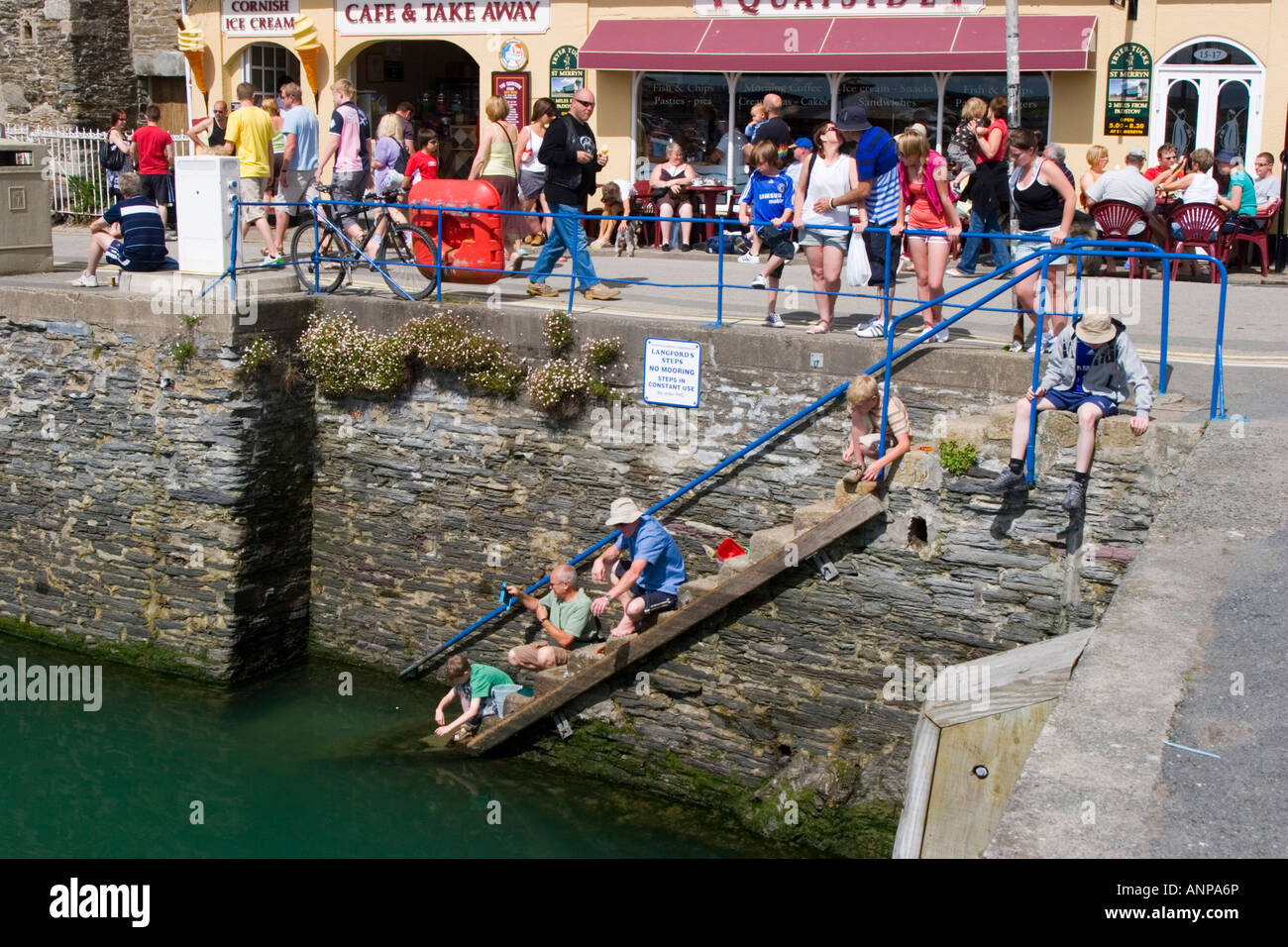 Crabbing on the steps of Padstow harbour in north Cornwall Stock Photo Alamy