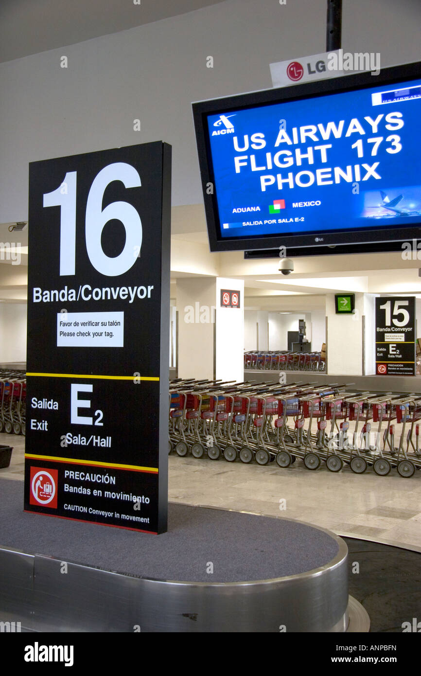 Spanish and English language signs above a baggage conveyor in the