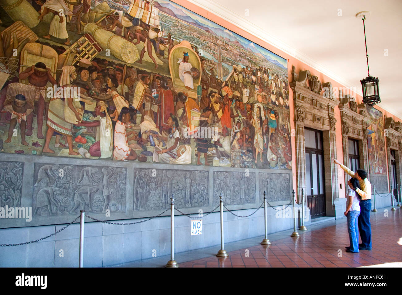 People look at a mural painted by Diego Rivera at the National Palace in Mexico City Mexico Stock Photo