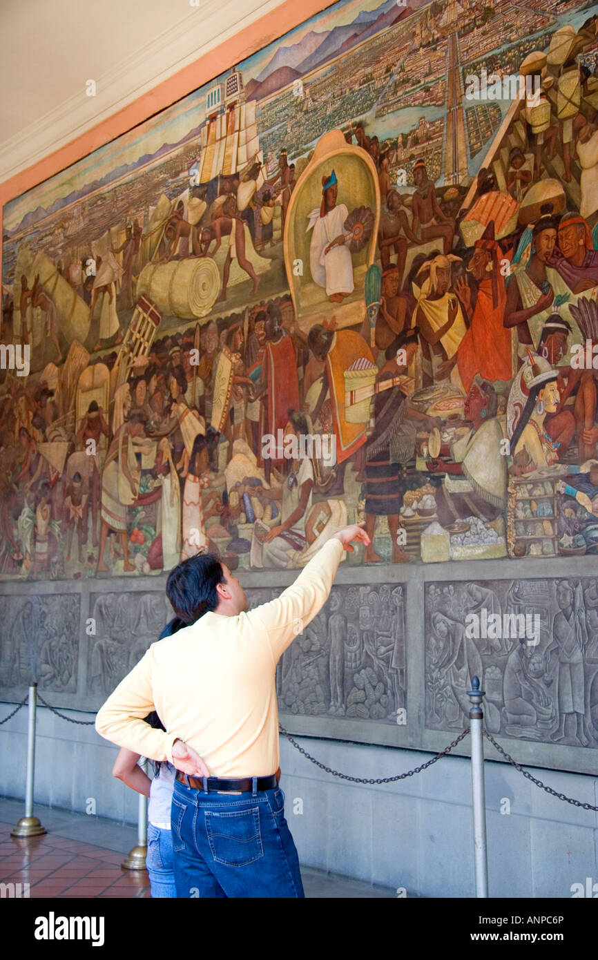 People look at a mural painted by Diego Rivera at the National Palace in Mexico City Mexico Stock Photo