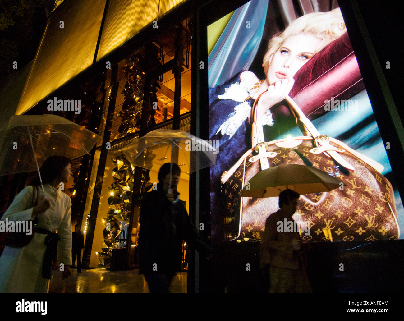 Night view of illuminated billboard in window of Louis Vuitton store in Omotesando Tokyo Japan Stock Photo