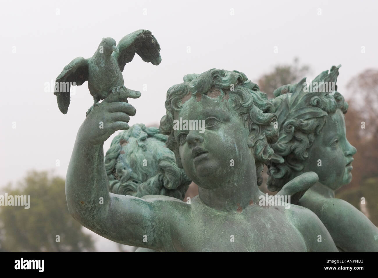 Statues of cherub holding pigeon The Parterre in the gardens of Chateau of Versailles Paris France Stock Photo
