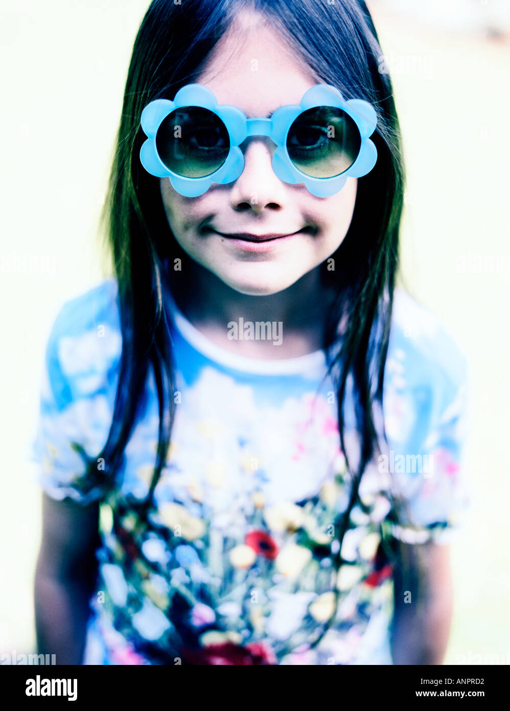 A young girl wearing blue flower sunglasses Stock Photo
