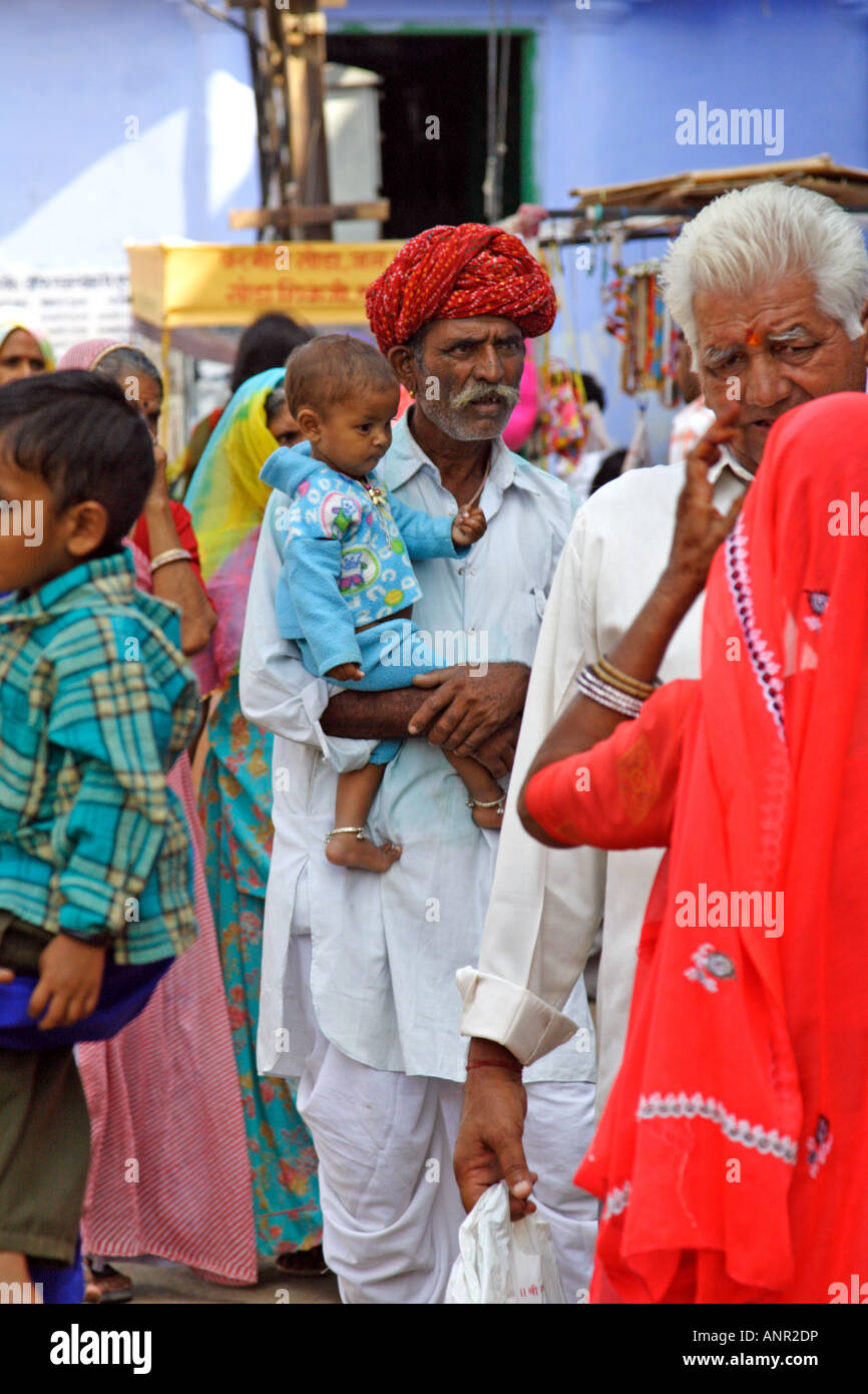Street scene with an old man with turban holding a baby in Pushkar, India Stock Photo