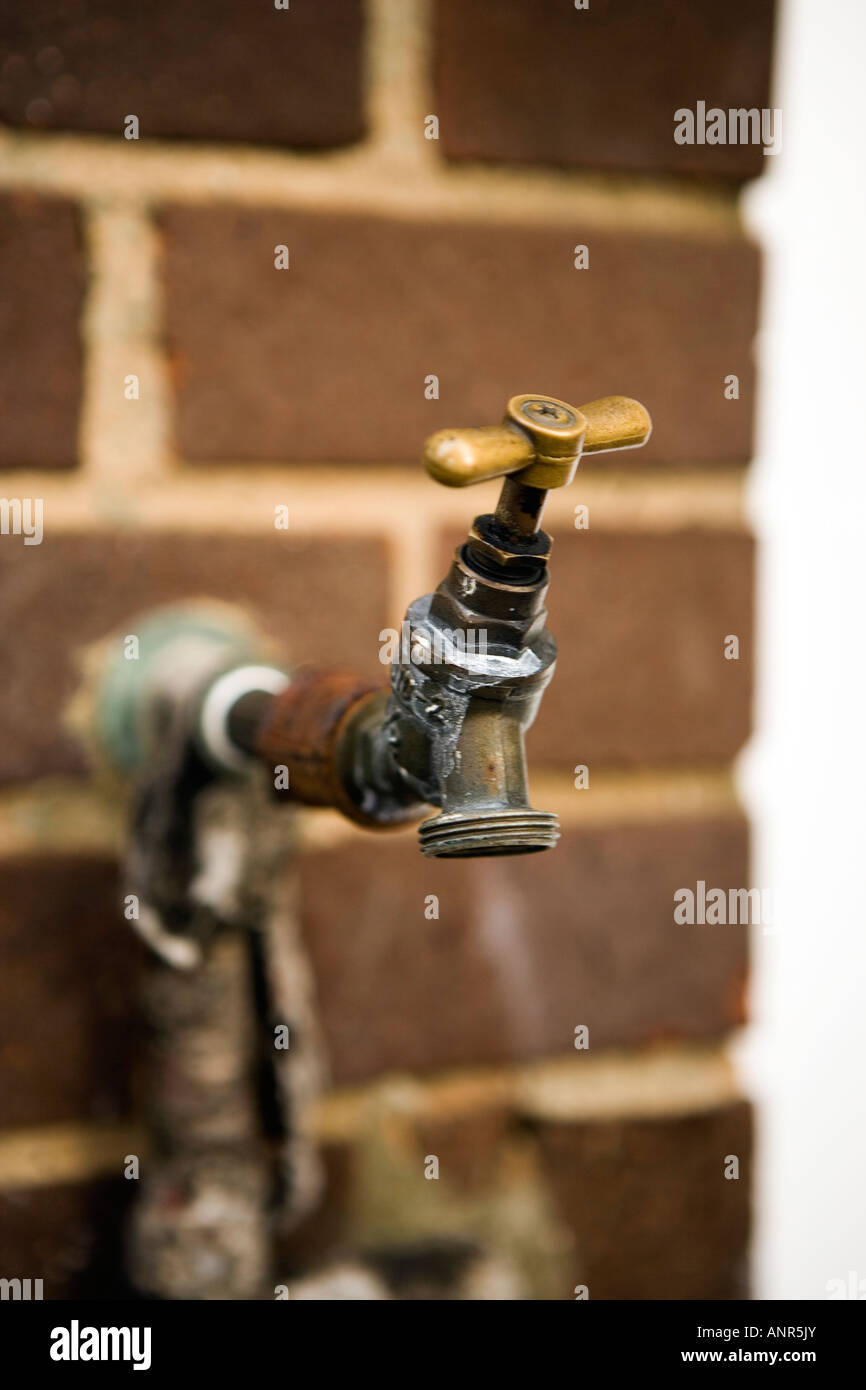 Outside Tap against a brick wall Stock Photo