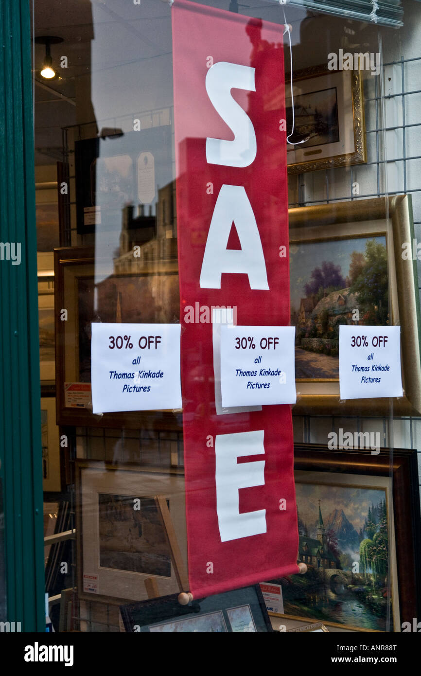Artwork on display inside a frame shop with 30 sale sign on the front window during the January