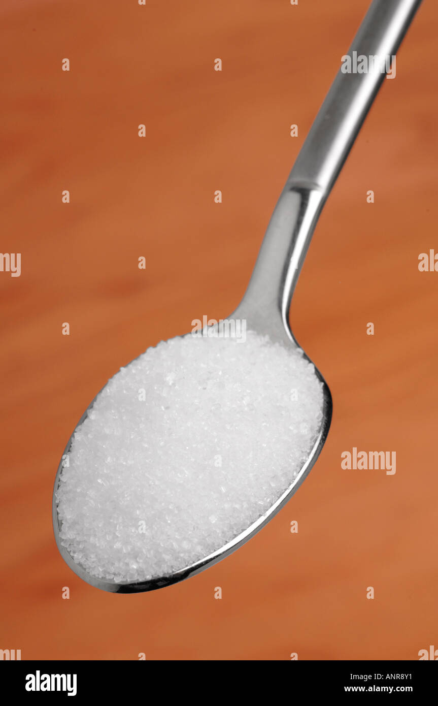 Granulated white sugar on teaspoon Stock Photo