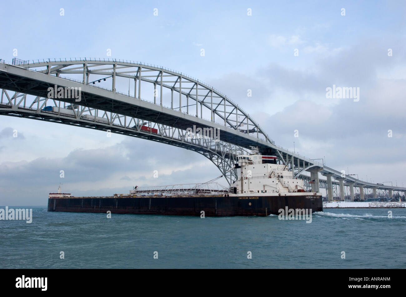 Freighter and the Blue Water Bridges spanning the St Clair river between Port Huron Michigan and Point Edward Ontario Stock Photo