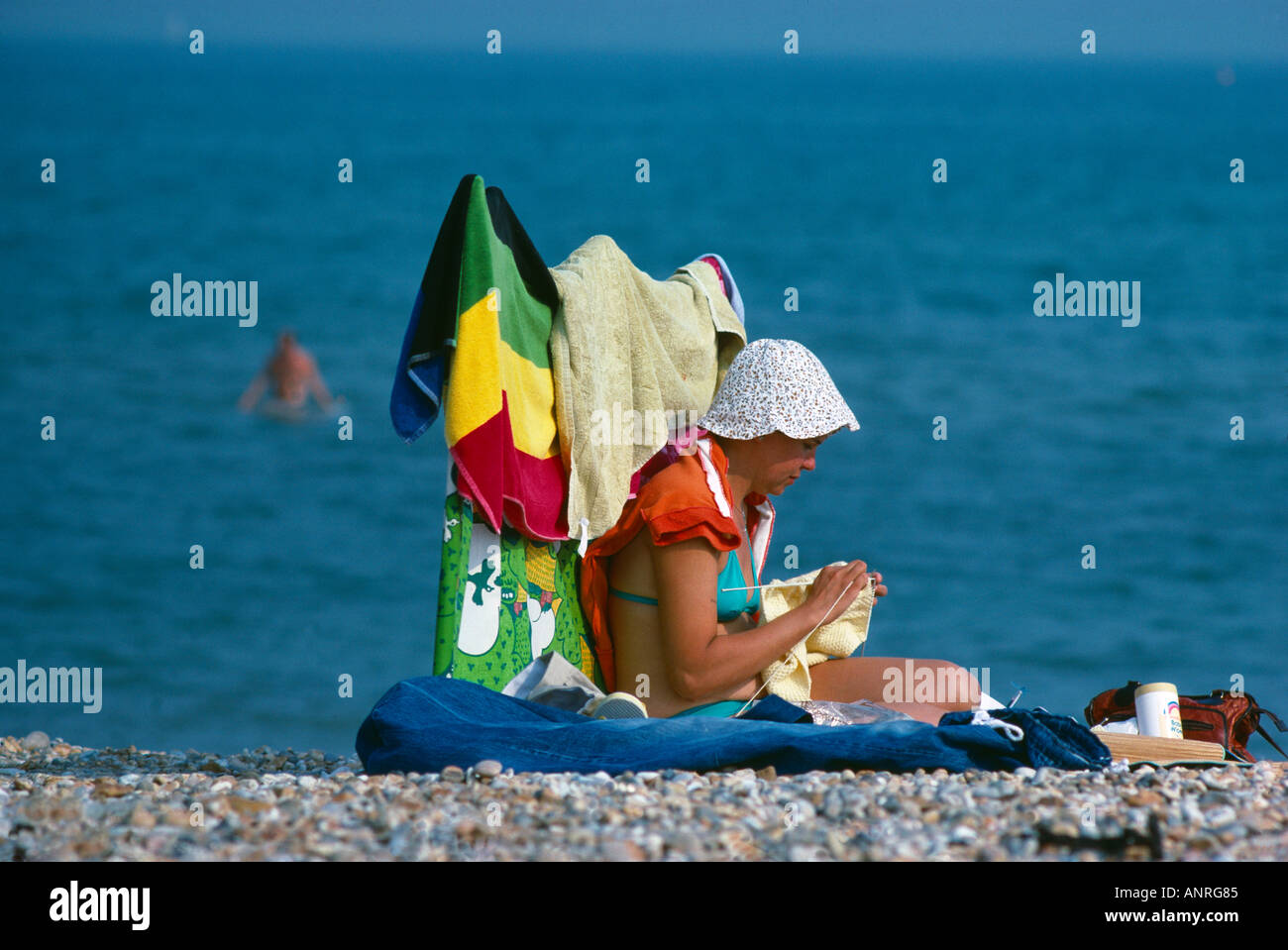 woman knitting on the beach the seaside Weymouth Dorset England UK Stock Photo