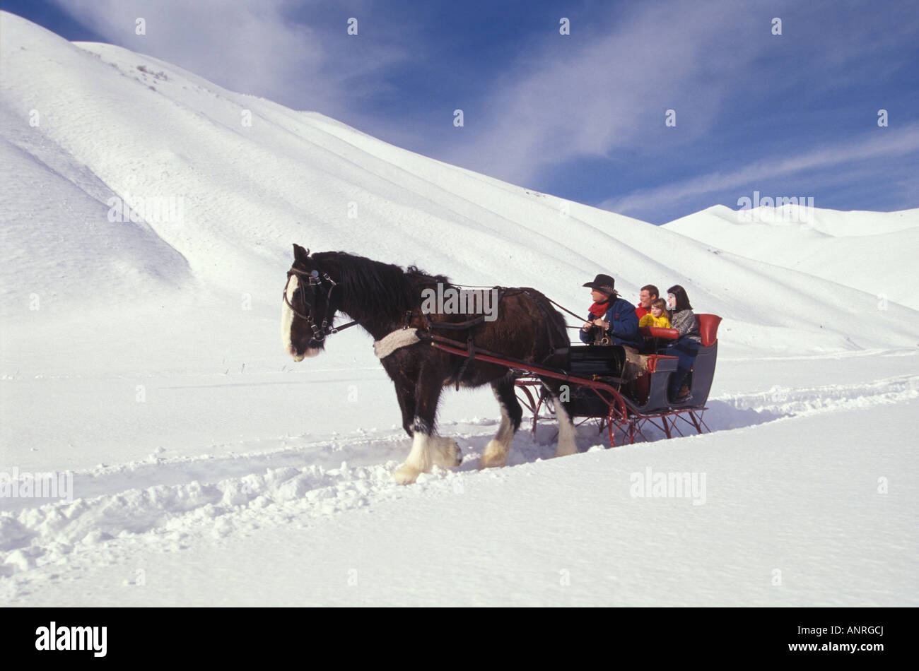 A couple and their four and a half year old daughter take a sleigh ride in Sun Valley Idaho Stock Photo