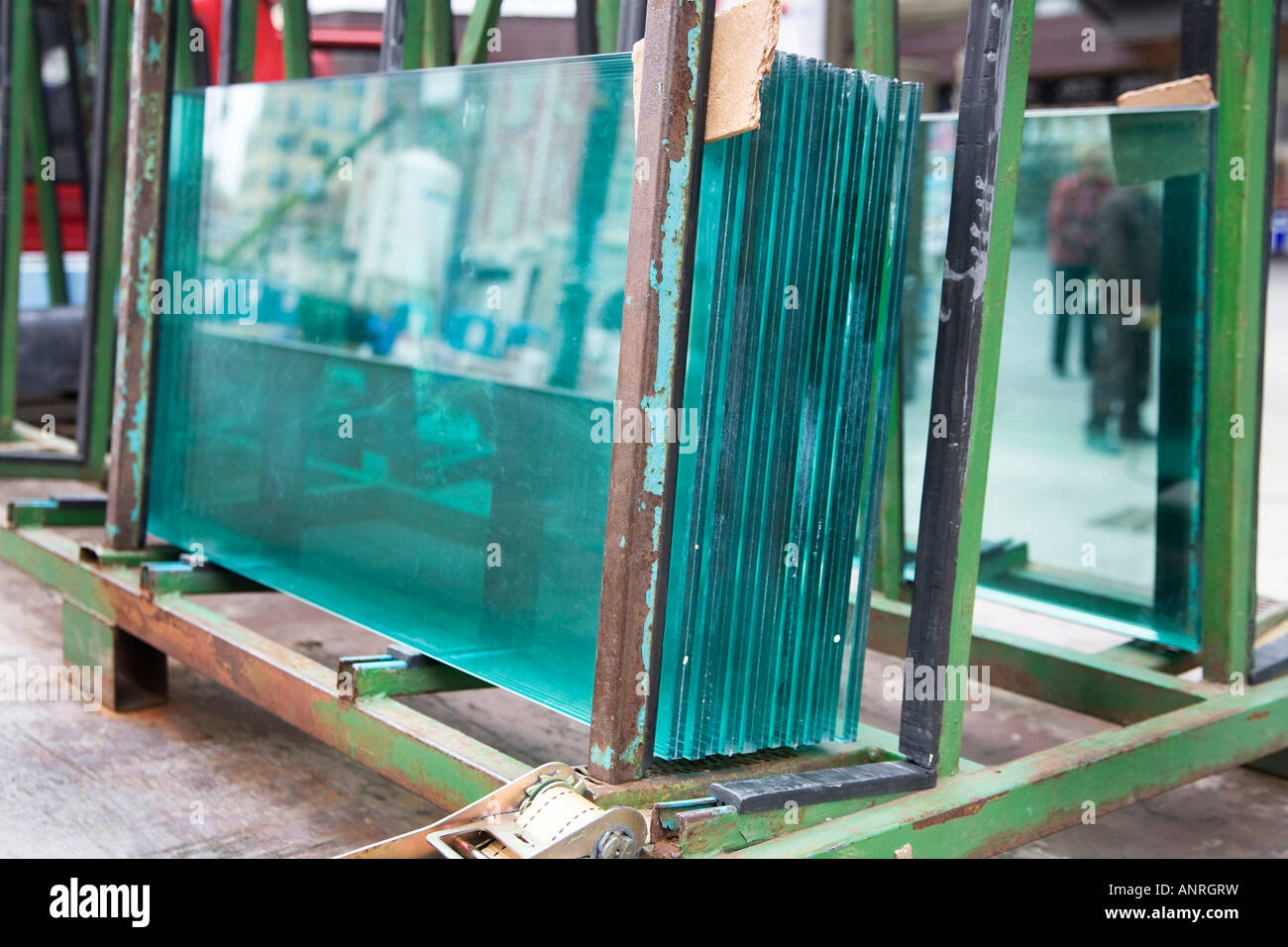 Sheets of plate glass sit on rack before installation in building being