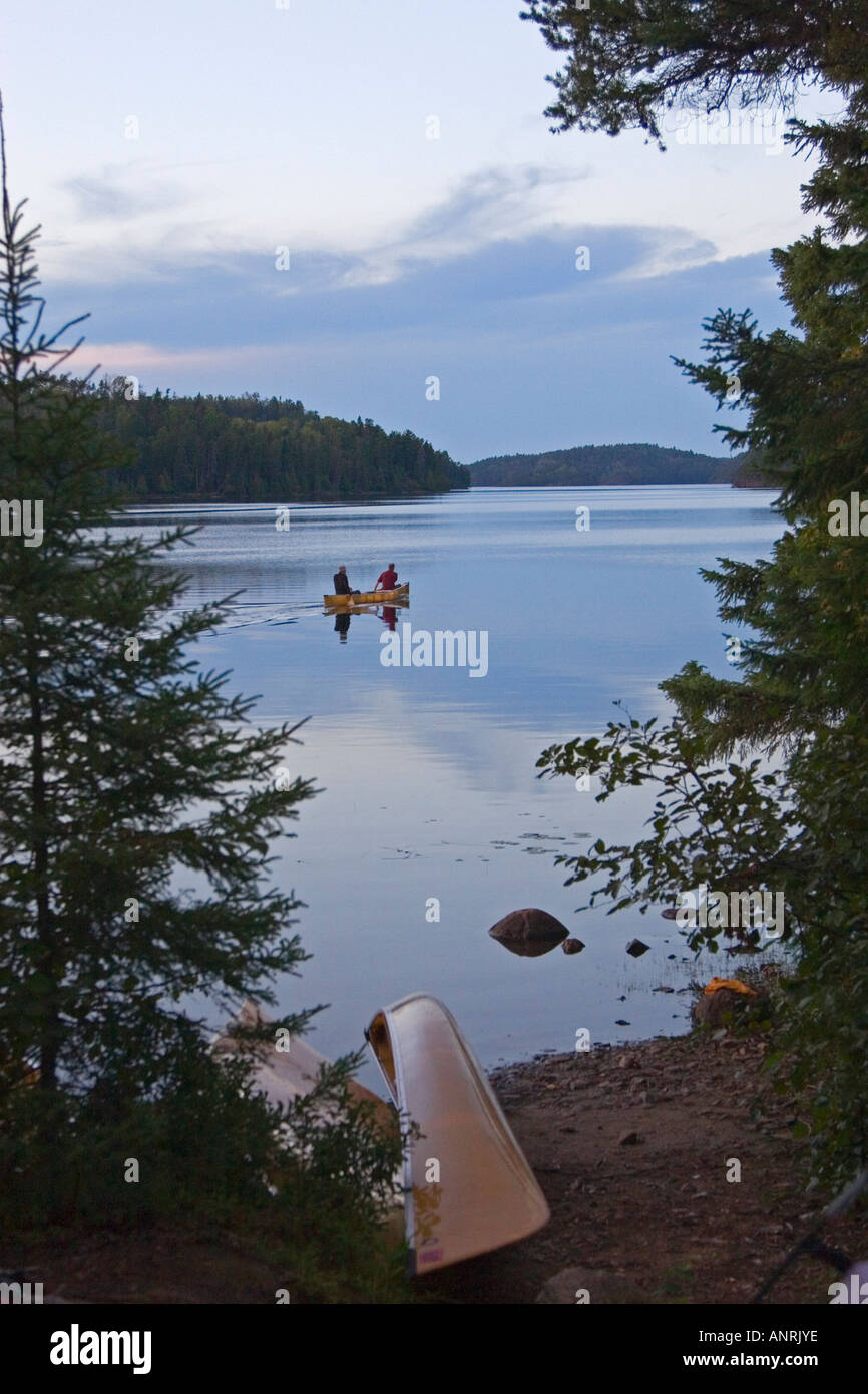 Quetico Provincial Park Ontario Canoers paddle on Agnes Lake at dusk