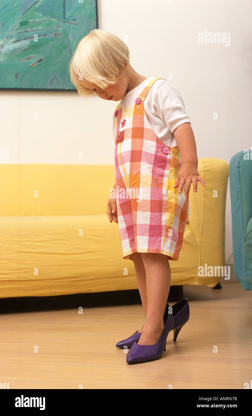 Girl is trying to walk on purple shoes with high heels Stock Photo - Alamy