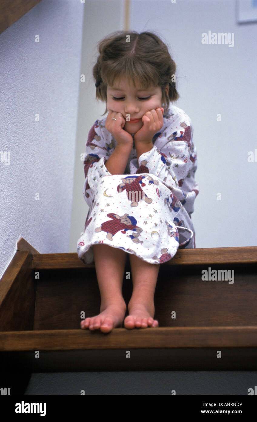Little girl sitting on a staircase in a sad mood Stock Photo - Alamy