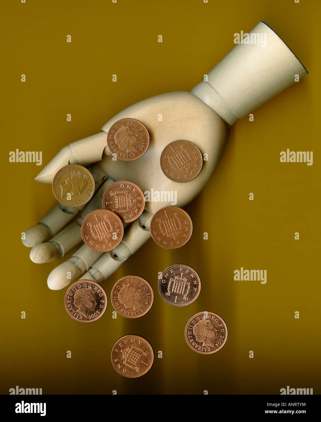 One penny coins fall from wooden hand, close-up Stock Photo