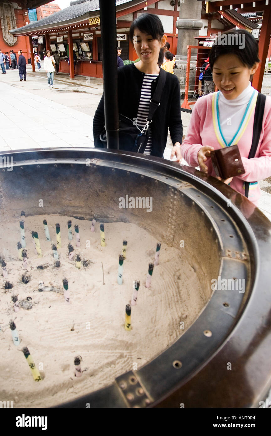 Stock photo of a Japanese woman burning incense at Sensoji temple in