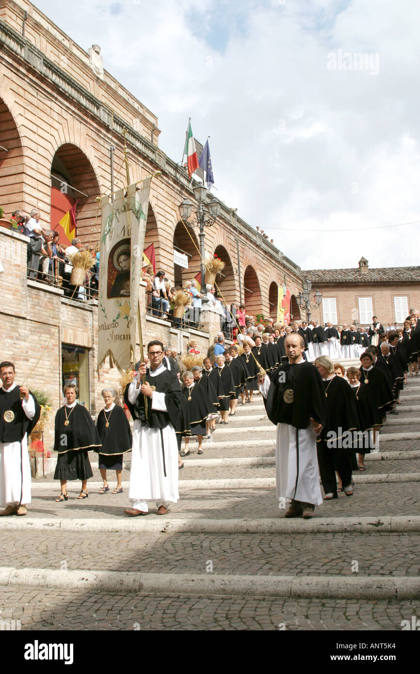 Procession of priests leading into Amandola Church during the  'Processione delle Canestrelle' Stock Photo
