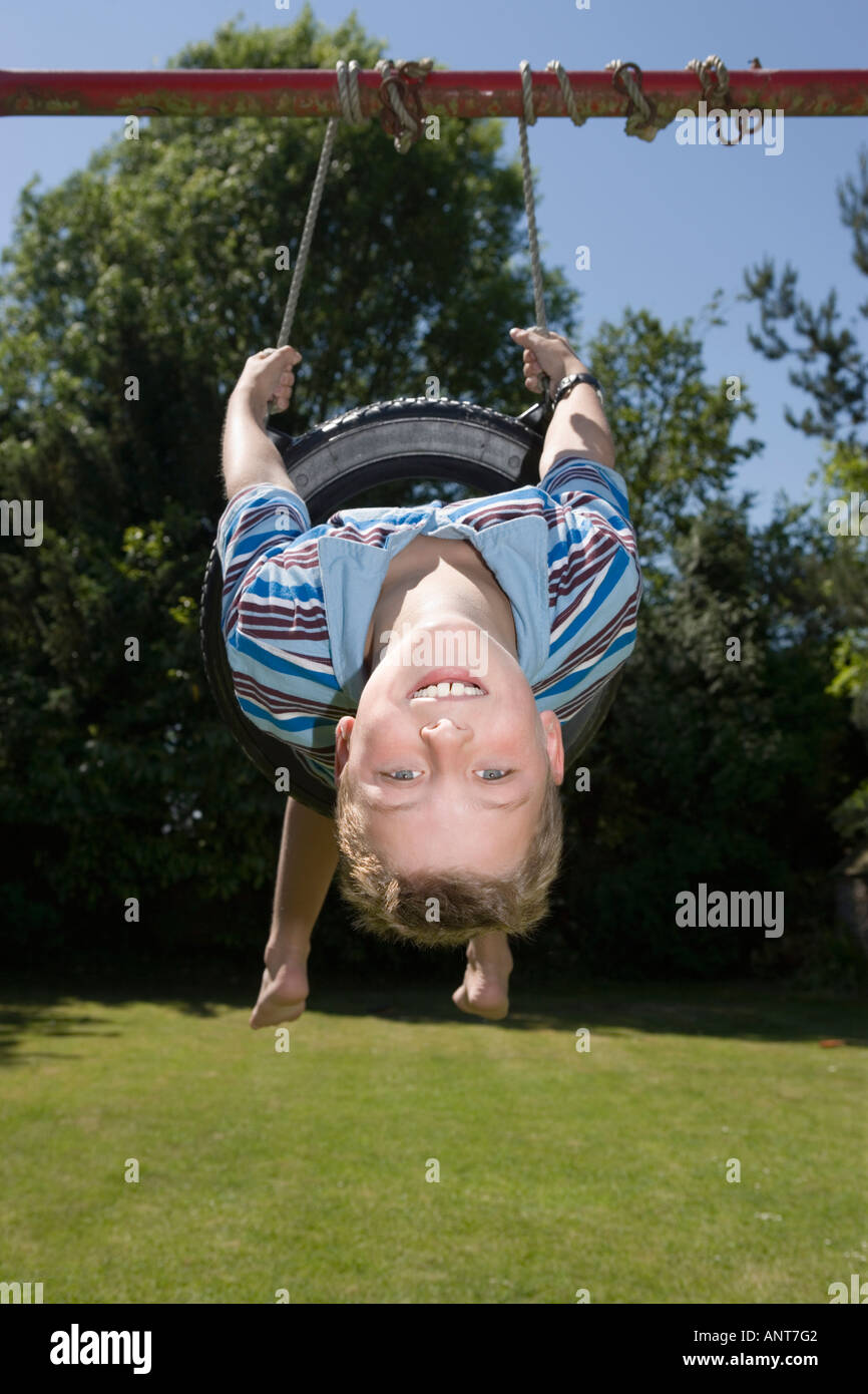 Boy on swing upside down Stock Photo Alamy