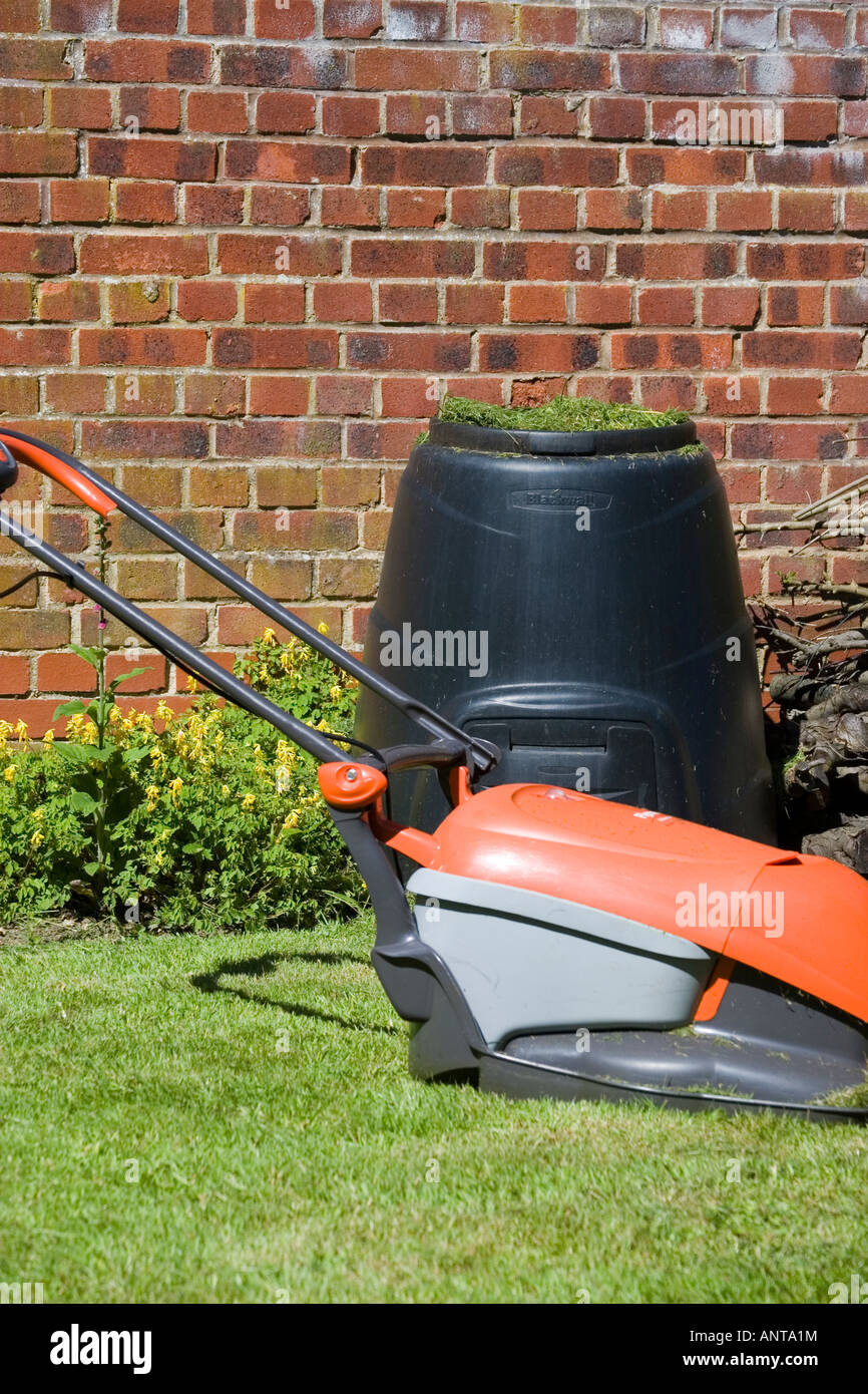 Lawnmower and composting bin with grass clippings Stock Photo