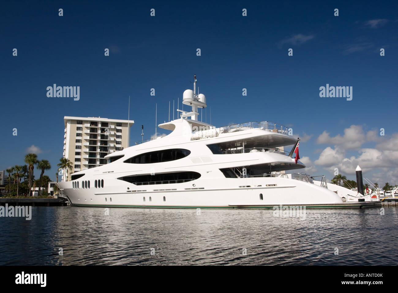 white mega yacht alongside dock with building in background Stock Photo