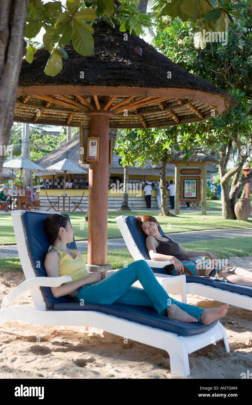 Two young women sitting on deck chairs Stock Photo