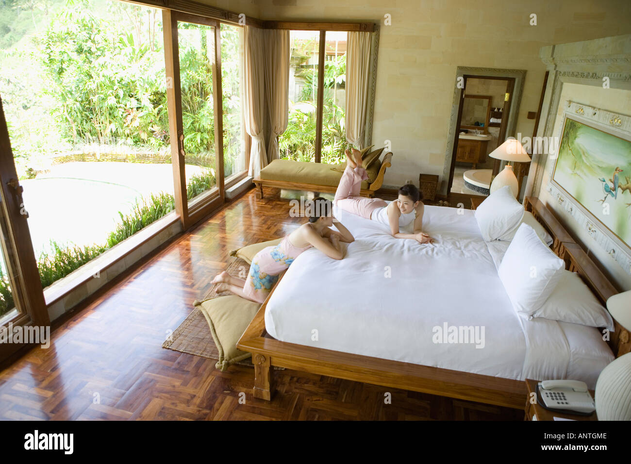 Two young women talking in bedroom Stock Photo