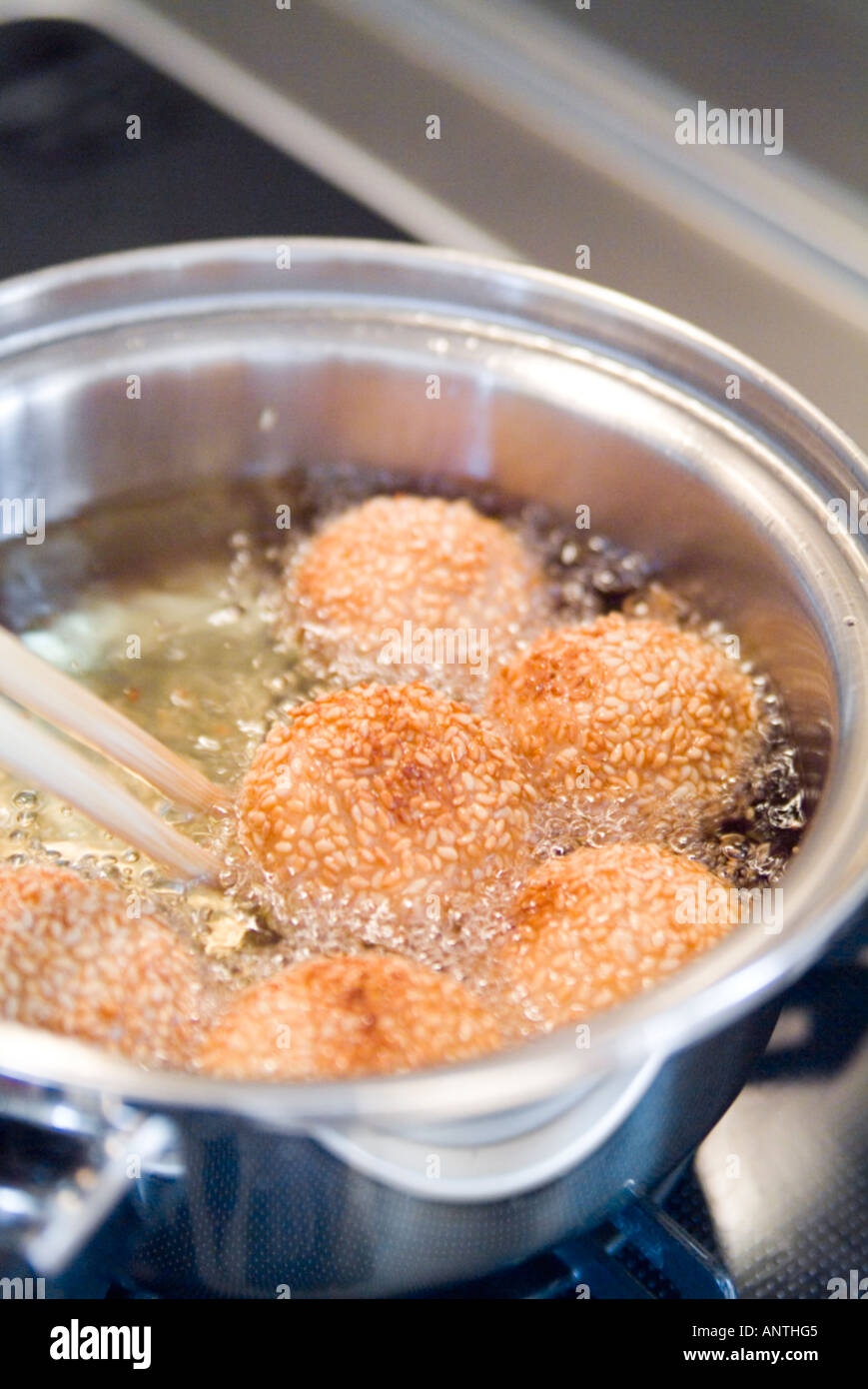 Deep frying sesame seed balls Stock Photo Alamy