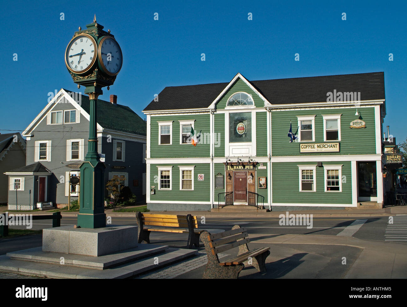 The four sided clock, down town, Wolfville, Nova Scotia, Canada. Green buildings in the background. Stock Photo