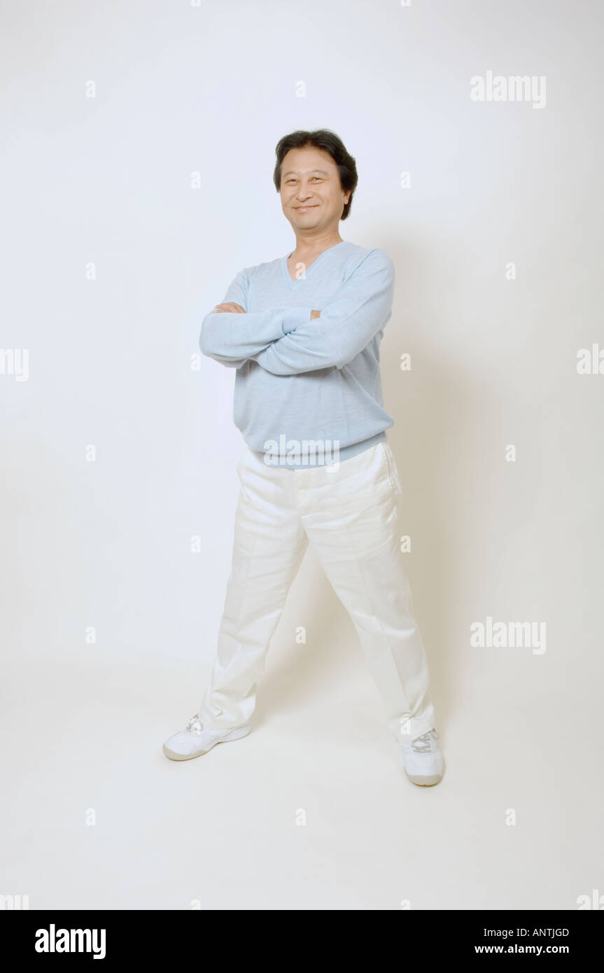 Mature man standing with his arms crossed Stock Photo - Alamy