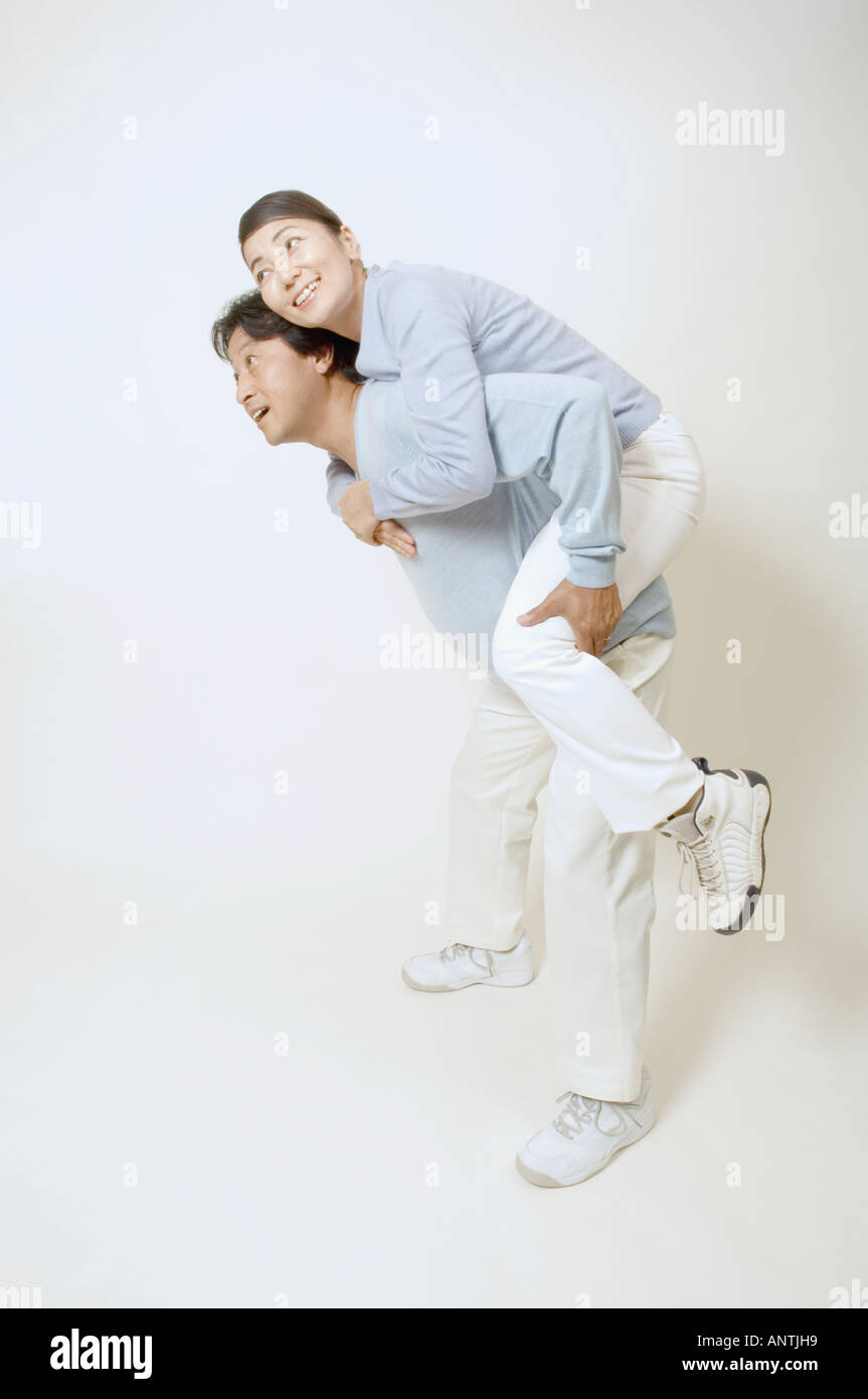 Mature man giving mature woman piggyback Stock Photo - Alamy