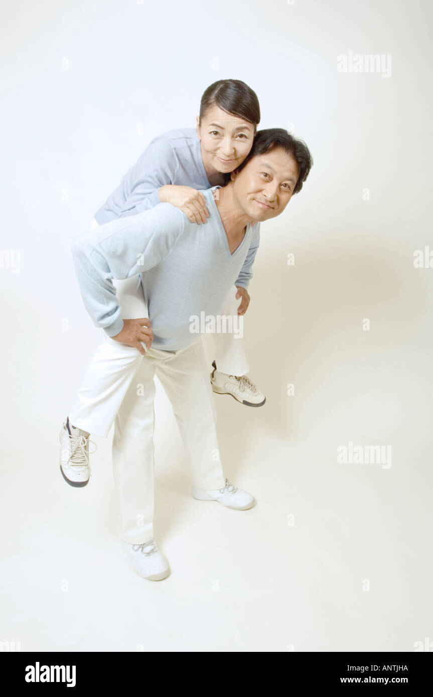 Mature man giving mature woman piggyback Stock Photo - Alamy