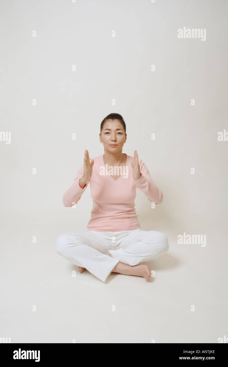 Mature woman sitting on floor Stock Photo - Alamy