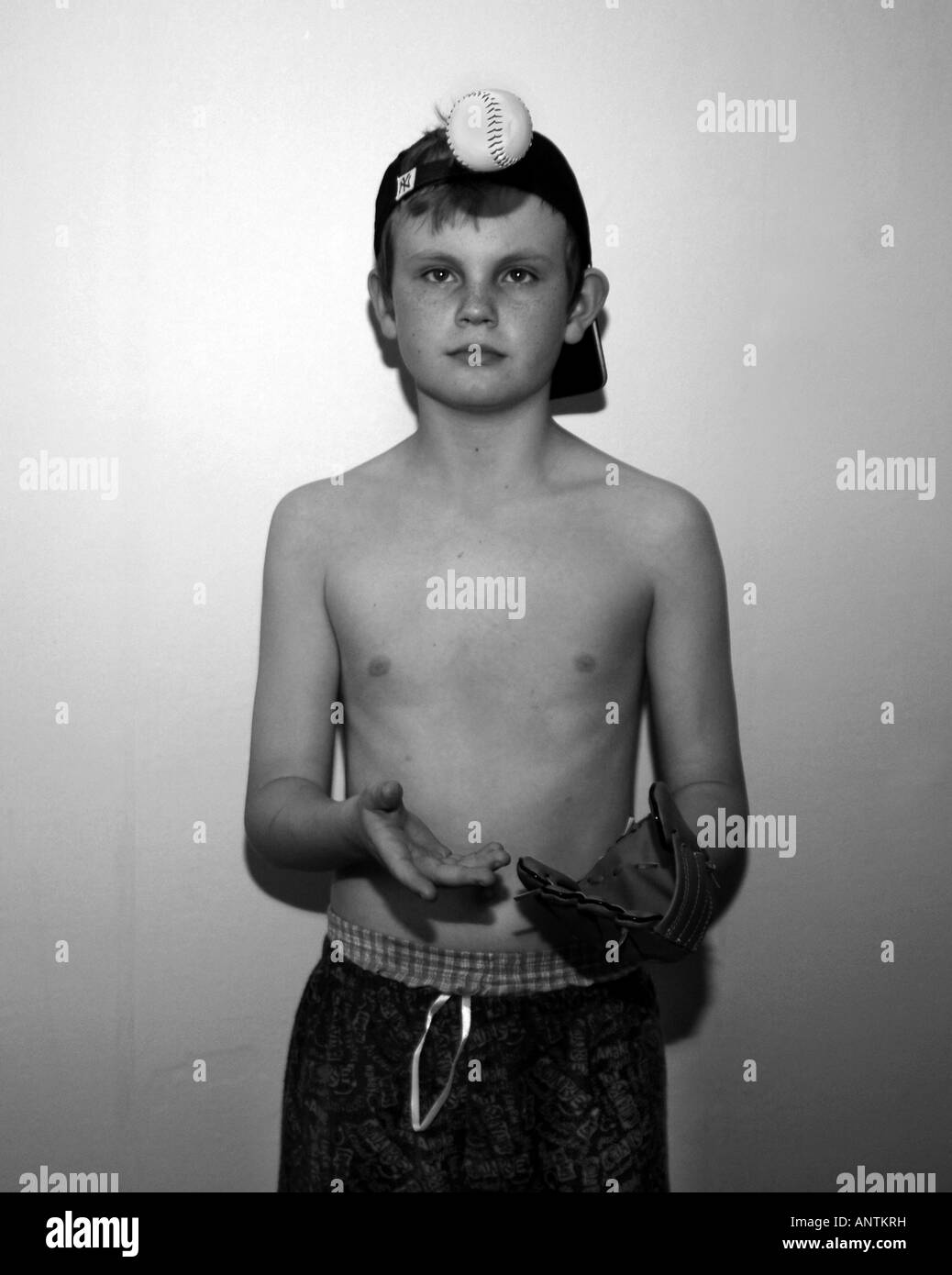 A B&W Image Of A 13 yr Old Boy Wearing A Baseball Cap & Mitt,Playing