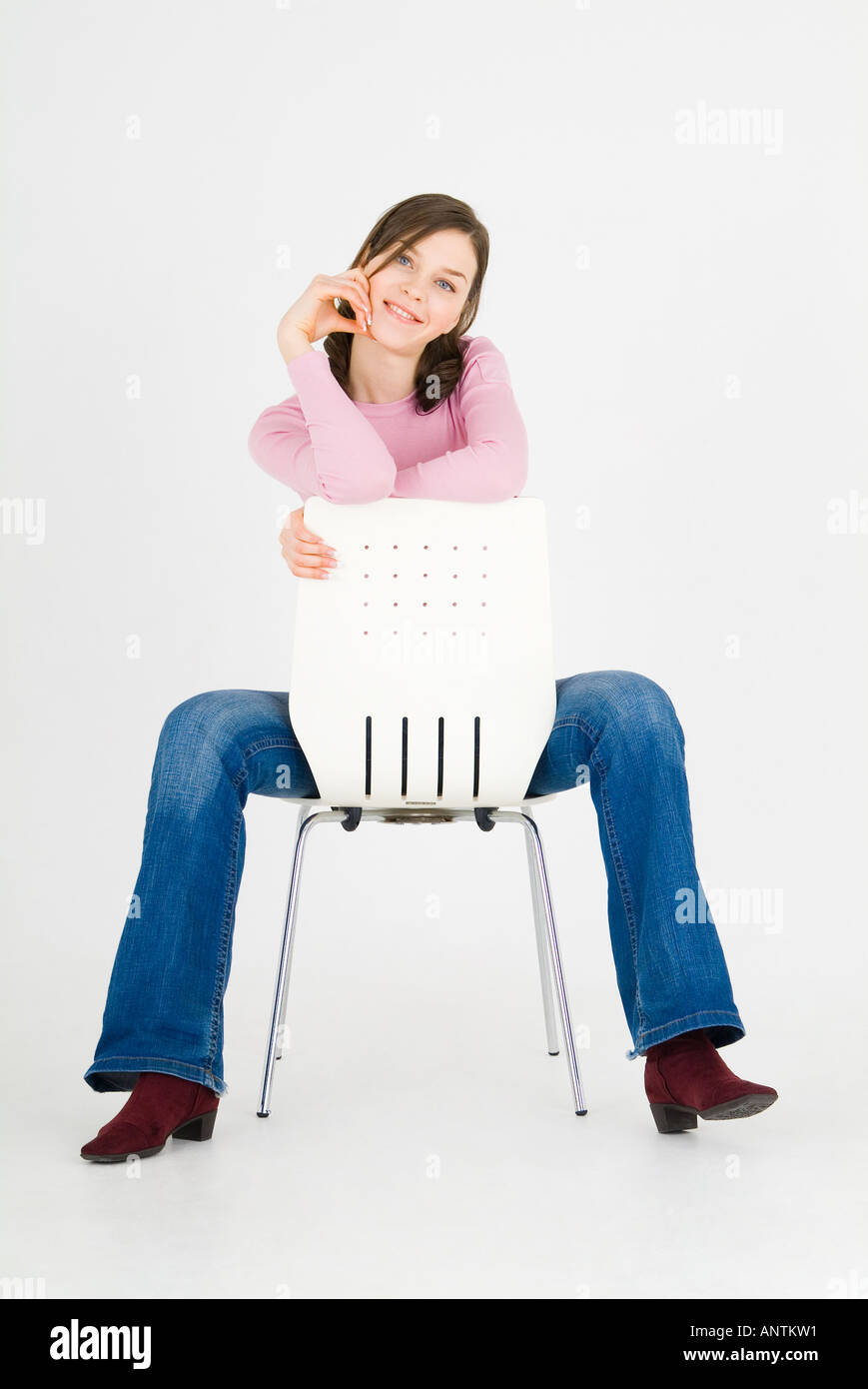 Young woman sitting backwards on chair Stock Photo Alamy