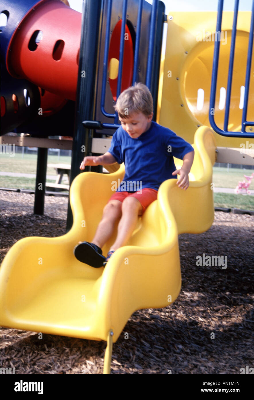 child sliding down a sliding board at a playground Stock Photo Alamy