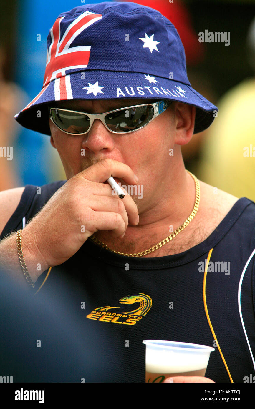 An Aussie male complete with nationalistic Flag sun hat cigarette beer and sunglasses Stock Photo