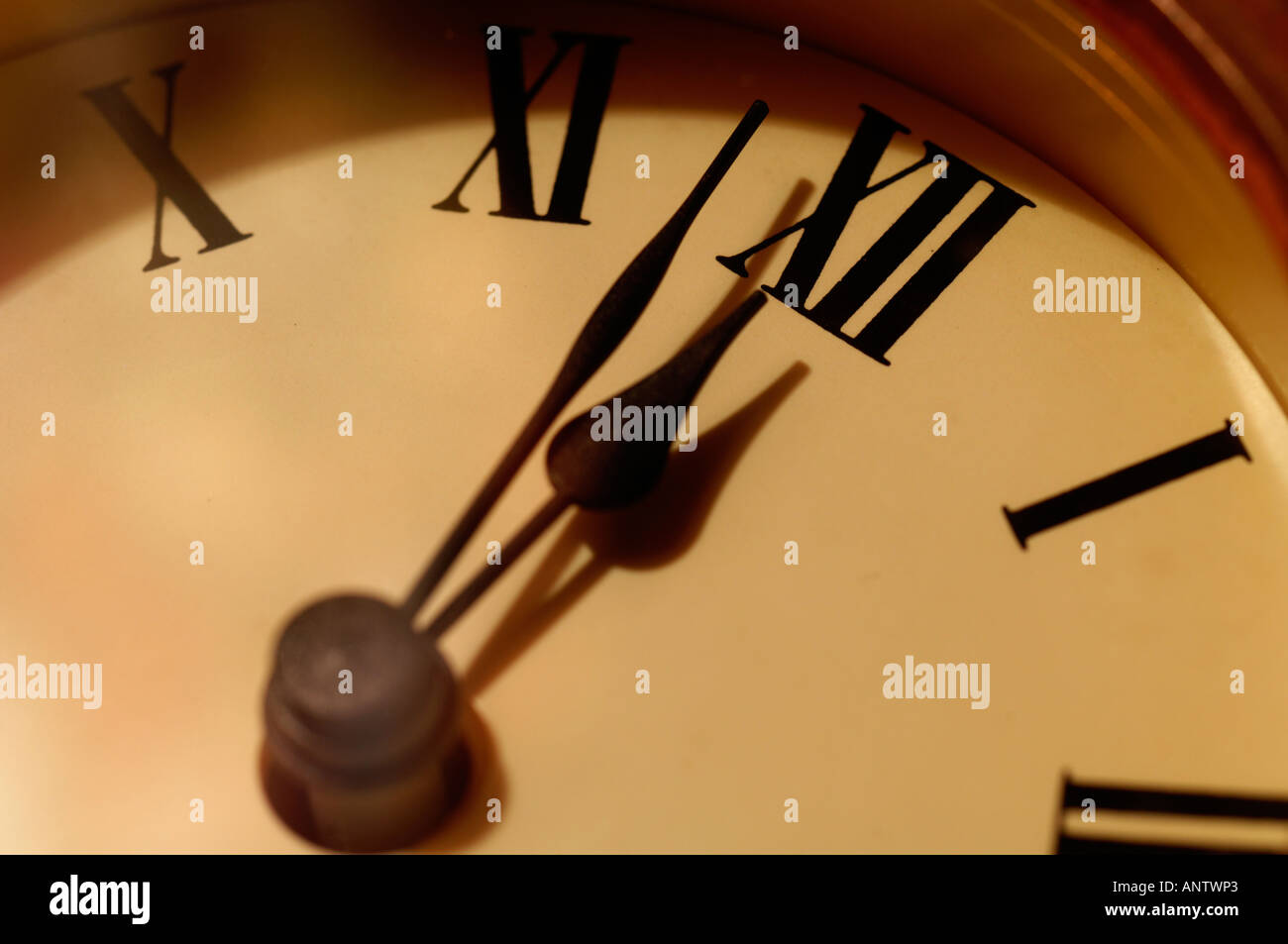 Close up of old fashioned clock face with hands at nearly twelve o