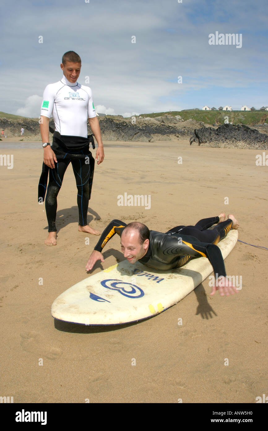 PRO SURFER ALAN STOKES GIVING POINTERS TO SURFER ON THE BEACH NEWQUAY UK Stock Photo