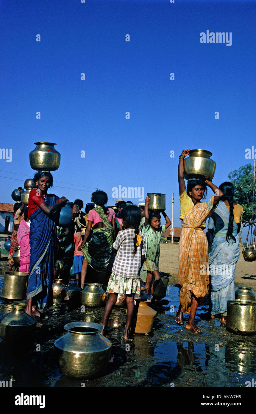 woman carrying water mugs from water well village near town of mysore state of karnataka india Stock Photo